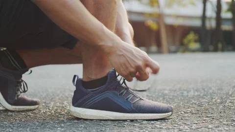 Asian man athlete tying jogging shoes prepare ready for running outdoors. Stock Footage 149392903