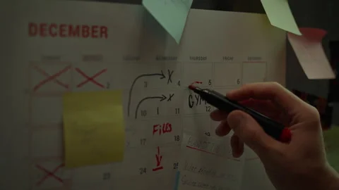 Asian man attaching sticky note to weekly planner. Marking goals for the wee Stock Footage 281685967