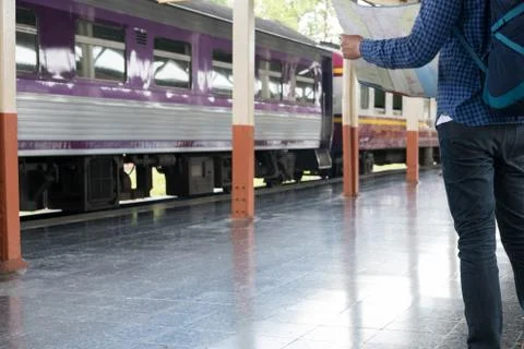 Asian man with backpack standing on platform at train station. backpacker or  Stock Photos