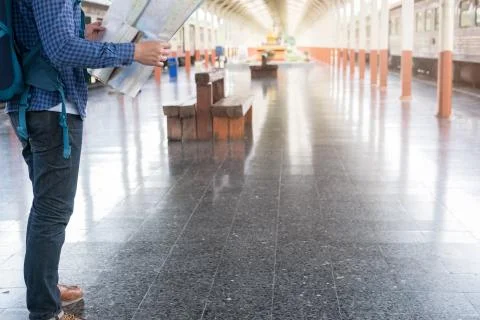 Asian man with backpack standing on platform at train station. backpacker or  Stock Photos