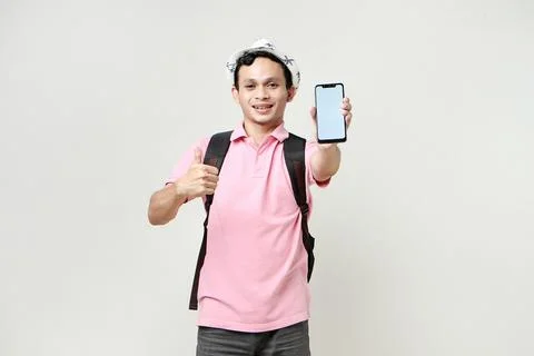 Asian man backpacker give thumb up and showing cellphone blank screen with .. Stock Photos