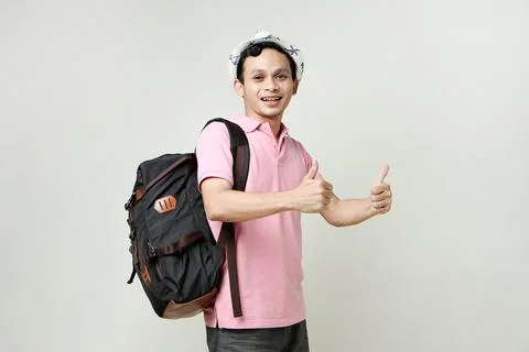 Asian man backpacker give thumb up gesture. digital nomad and travelling co.. Stock Photos