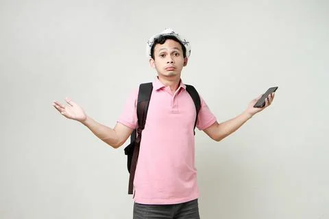 Asian man backpacker hold mobile phone with confused expression. travelling.. Stock Photos