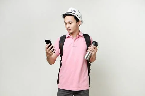Asian man backpacker hold mobile phone and tumbler bottle. travelling conce.. Stock Photos