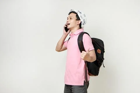 Asian man backpacker making a phone call with thumbs up gesture. digital no.. Stock Photos