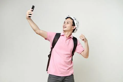 Asian man backpacker taking selfie photos with mobile phone. digital nomad .. Stock Photos