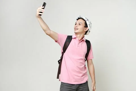 Asian man backpacker taking selfie photos with mobile phone. digital nomad .. Stock Photos