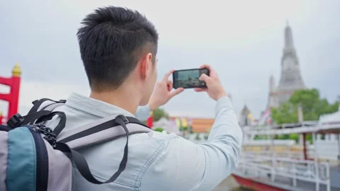 Asian man backpacker using mobile phone take picture of Buddha temple. Stock Footage 171263056