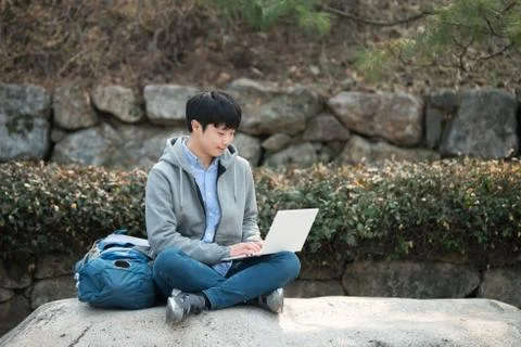 Asian man backpacking using laptop Stock Photos