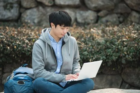 Asian man backpacking using laptop Stock Photos