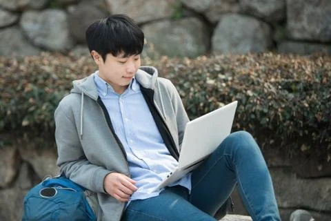 Asian man backpacking using laptop Stock Photos
