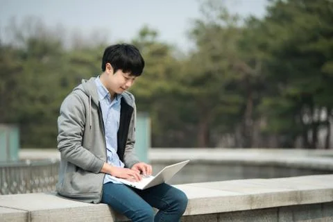Asian man backpacking using laptop Stock-Fotos