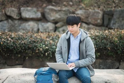 Asian man backpacking using laptop Stock Photos