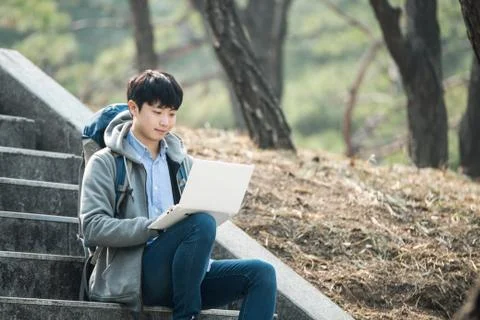 Asian man backpacking using laptop Stock Photos