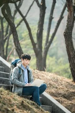 Asian man backpacking using laptop Stock Photos