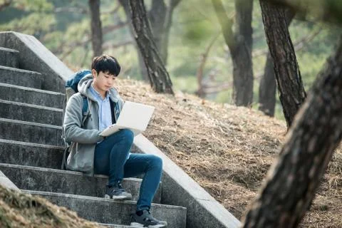 Asian man backpacking using laptop Stock Photos
