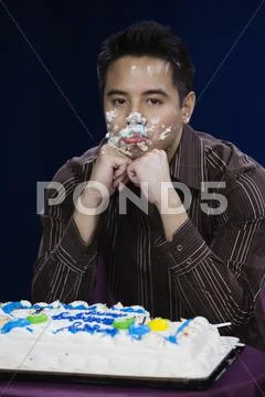 Asian Man With Birthday Cake On Face