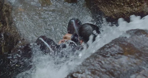 Asian man in a black suit under a waterfall, Thailand Stock Footage 234869166