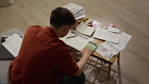 Asian Man Calculating Past Due Utility Bills with Calculator Vídeos de archivo 344648090