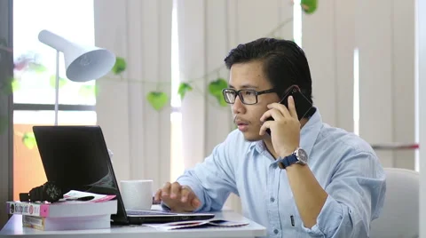 Asian Man Calling and Typing at Office - Slow Motion Stock-Footage 60605816
