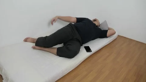 Asian man checking his phone directly after waking up on bed in the morning Stock Footage 295982733