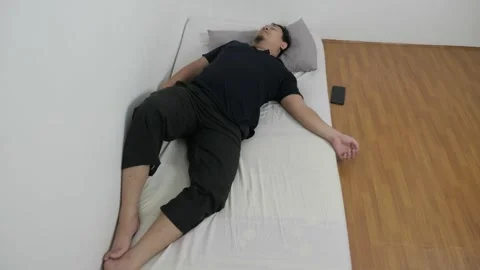 Asian man checking his phone directly after waking up on bed in the morning Video stock 295993850