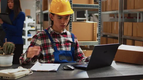 Asian man checking merchandise quality in warehouse Stock Footage 236431473