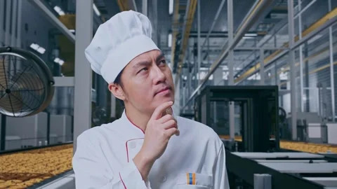 Asian Man Chef Thinking Then Raising His Index Finger In Cookie Factory Vidéo 318081073