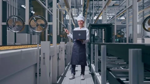 Asian Man Chef Using A Laptop And Pointing To Side In Cookie Factory Stock Footage 318083036