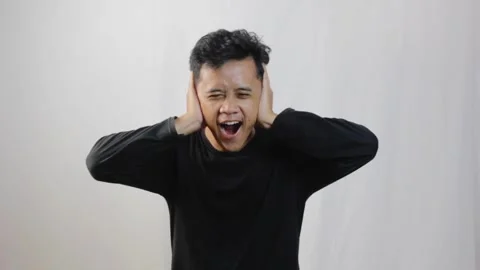 Asian man covering ears while shouting Stock Footage 319059336
