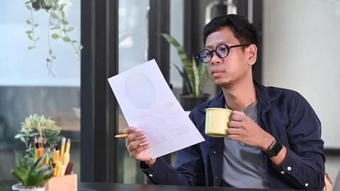 Asian man creative designer drinking coffee and working with color swatch in Foto stock