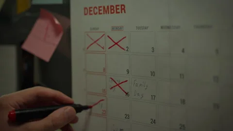 Asian man crossing out completed tasks on a planning calendar. He crosses ou Stock Footage 281087115