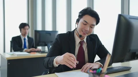 Asian man is customer support agent, call center works on desktop computer Stock Footage 225429174