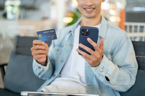 Asian man customer using smartphone and credit card for a secure online pay.. Stock Photos