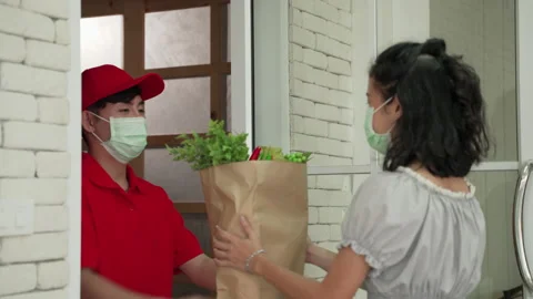 Asian man delivery workers bringing vegetable food to the doorstep Stock Footage 141995724