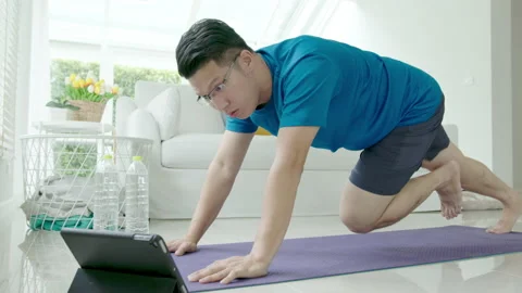 Asian man doing mountain climber in living room at home with pet 스톡 동영상 139326860