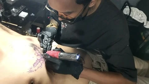 An asian man doing tattoo Stock Footage 342310230