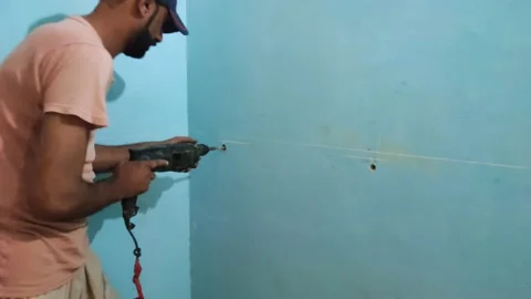 An asian man is drilling in a wall Stock Footage 162335940
