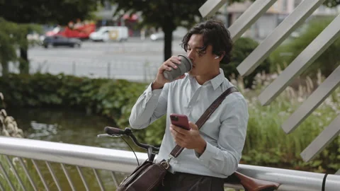 Asian man drinking coffee and using mobile on street Video stock 166564618