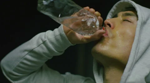 Asian man drinking water after a workout in slow motion Stock Footage