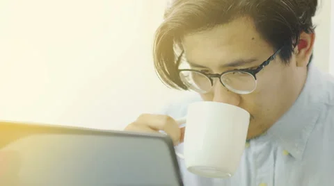 Asian Man Drinks Coffee While Working on Laptop Close Up - 4K Resolution Stock Footage 60616330