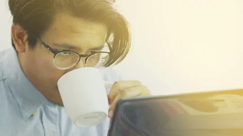 Asian Man Drinks Coffee While Working on Laptop Close Up - Slow Motion Stock Footage 60616556