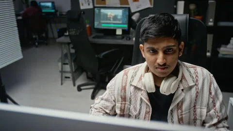 Asian Man Editing Video on Computer in Office Stock Footage 348354124