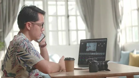 Asian Man Editor Talking On Mobile Phone With Video Editing App / Software Stock-Footage 153229975