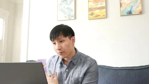 Asian man educator instructing an online class using cards with pictures Stock Footage 247480070
