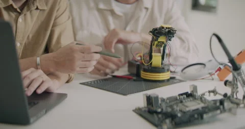 Asian Man Engineers Testing Robotic Arm Prototype with Microcontroller. Stock Footage 308232517