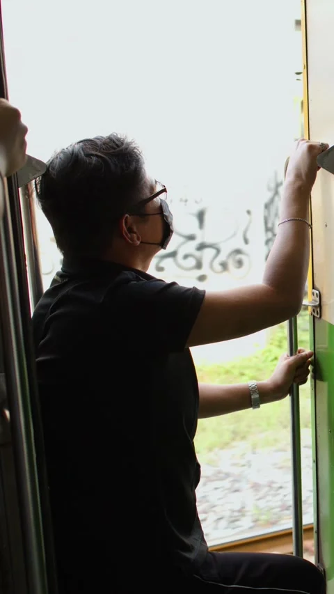 Asian Man in Face Mask Looking Out Open Train Door Video stock 339513569