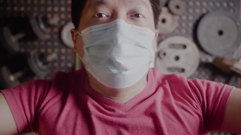 Asian man with face mask while bench pressing at home during pandemic, closeup Stock Footage 148130098