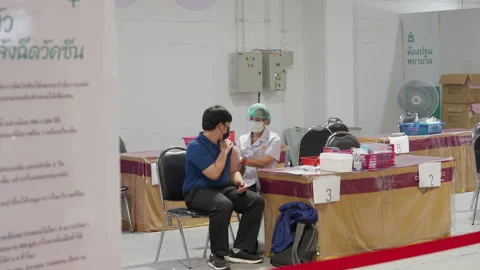 Asian Man Gets Covid Flu Vaccine Injection By Female Nurse At Indoor Asia Clinic Video stock 256095319