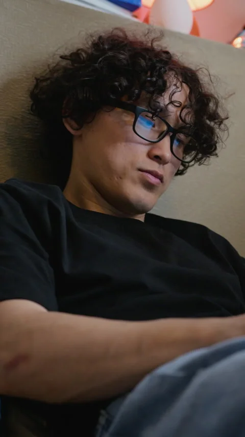 Asian Man with Glasses Using Digital Device with Blue Light Reflection Stock Footage 338422119